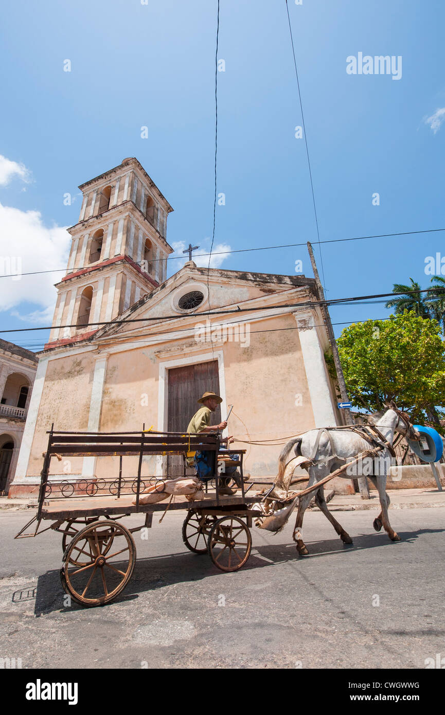 Cuban man riding a horse and buggy in front Iglesia del buen Viaje catholic church, Remedios, Cuba. Stock Photo