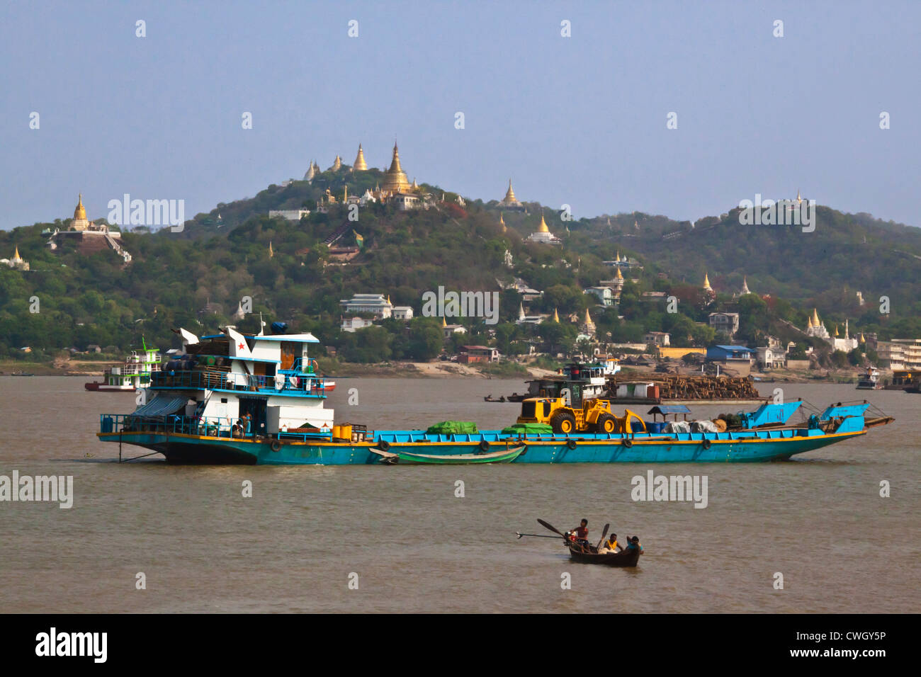 Boat traffic on the IRRAWADDY RIVER with SAGAING HILL behind - MANDALAY, MYANMAR Stock Photo