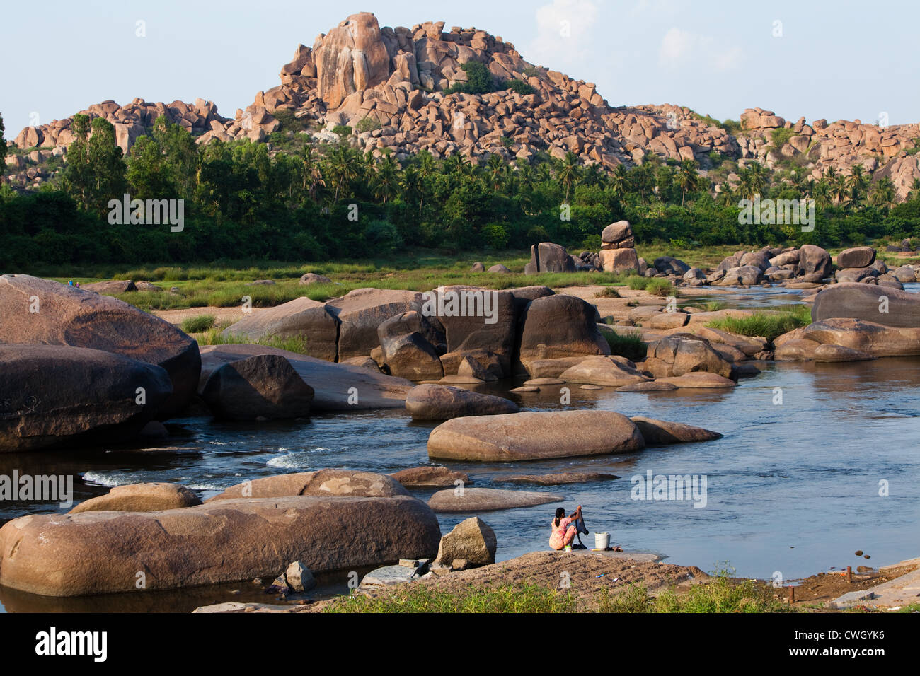 Indian woman washing clothes in the Tungabhadra river in Hampi Stock Photo