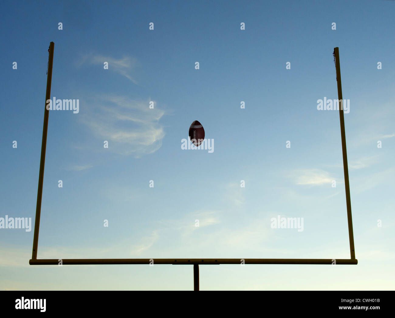 Football being thrown through goal posts Stock Photo