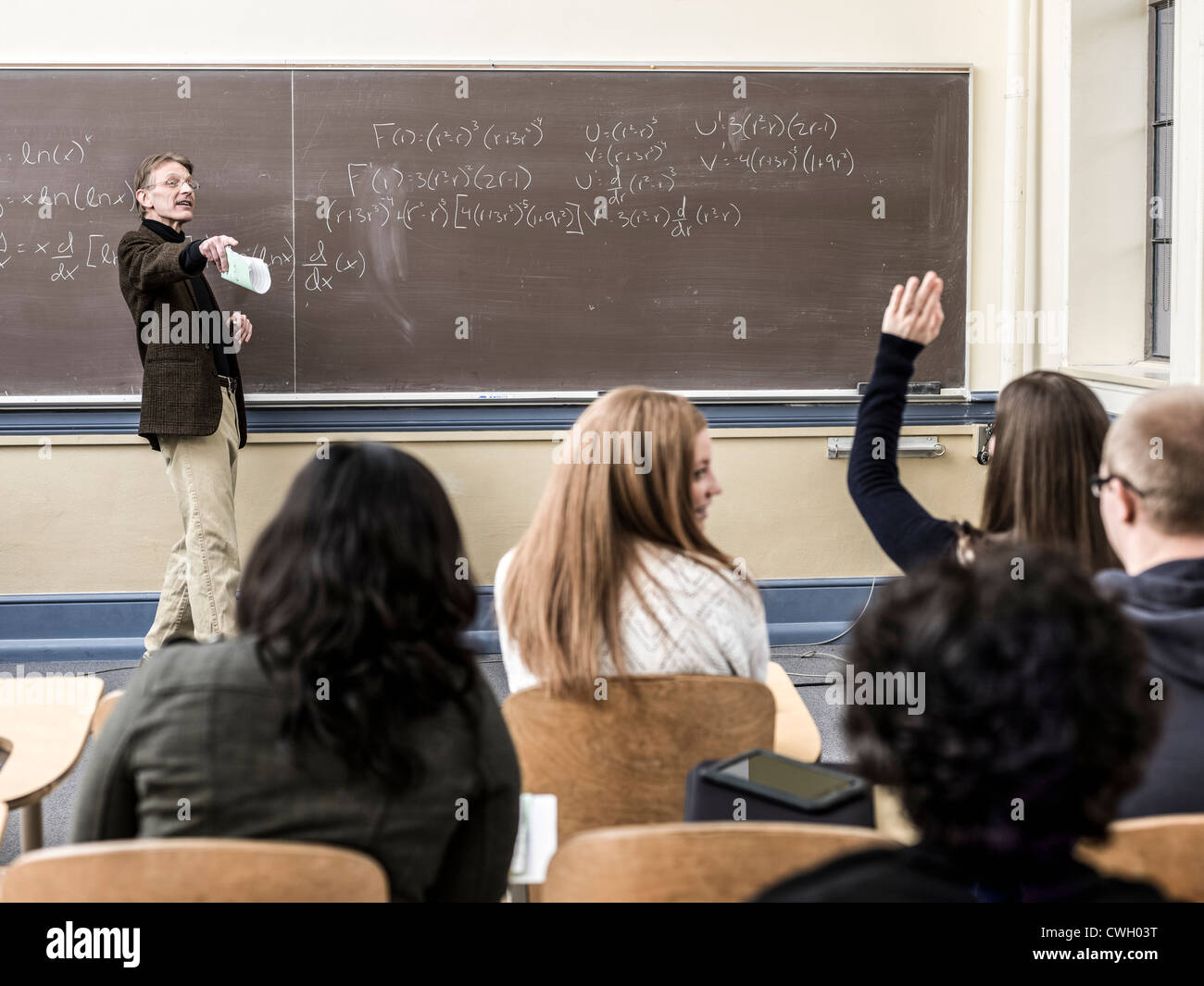 Teacher talking to students in classroom Stock Photo - Alamy