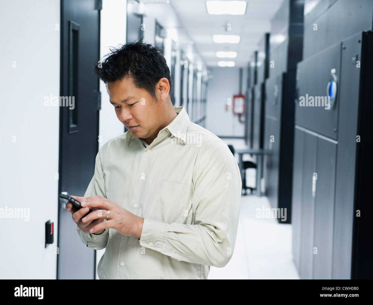 Asian businessman using cell phone in server room Stock Photo Alamy