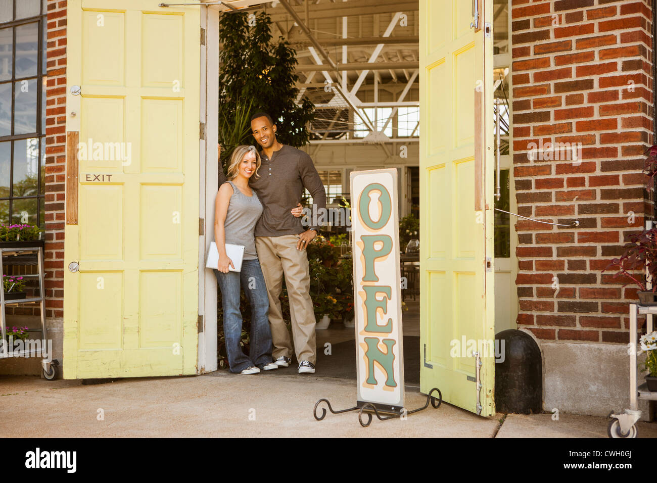 Couple standing in flower shop doorway Stock Photo