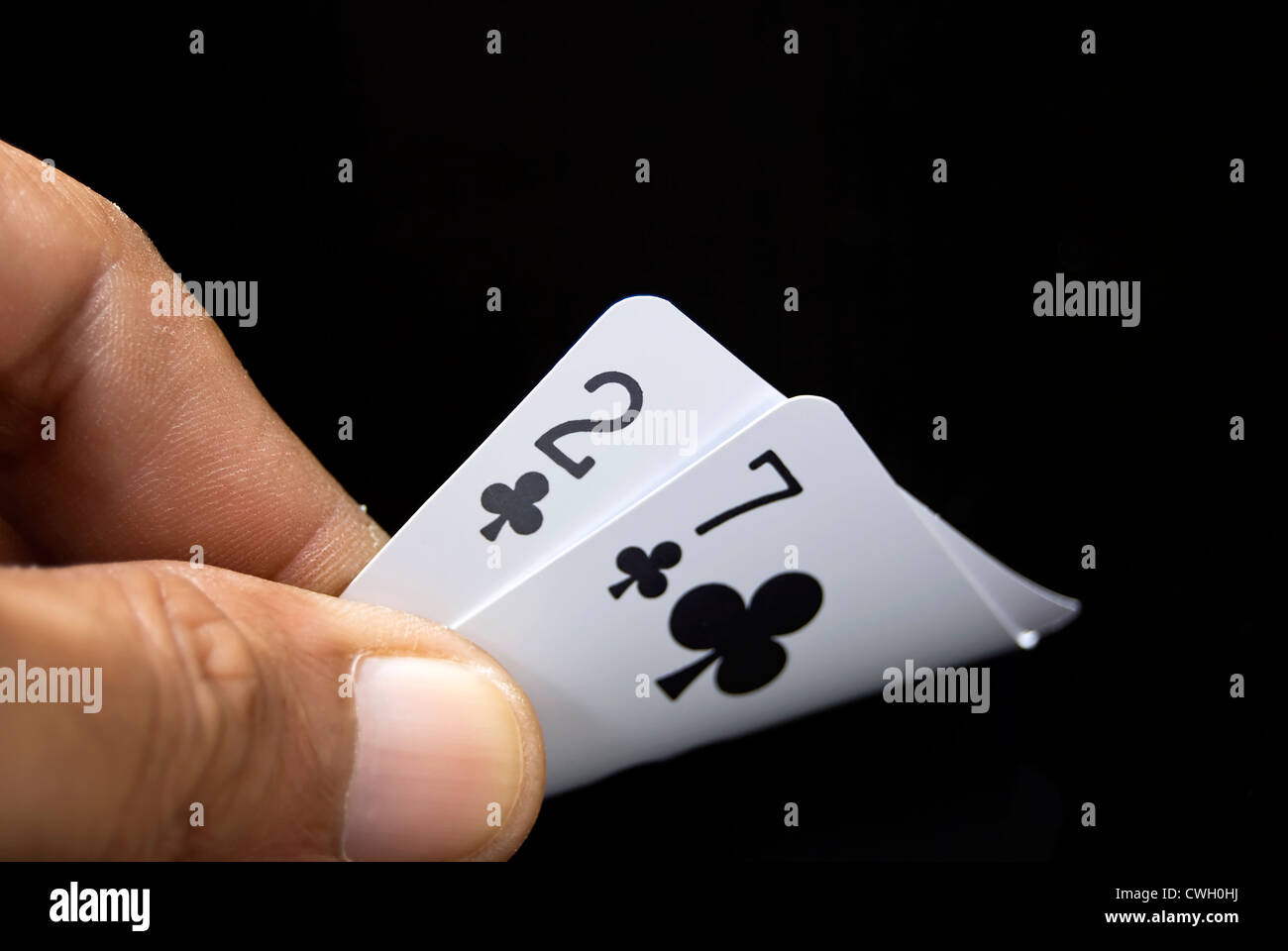 Lucky Nine cards held by hand against black background Stock Photo
