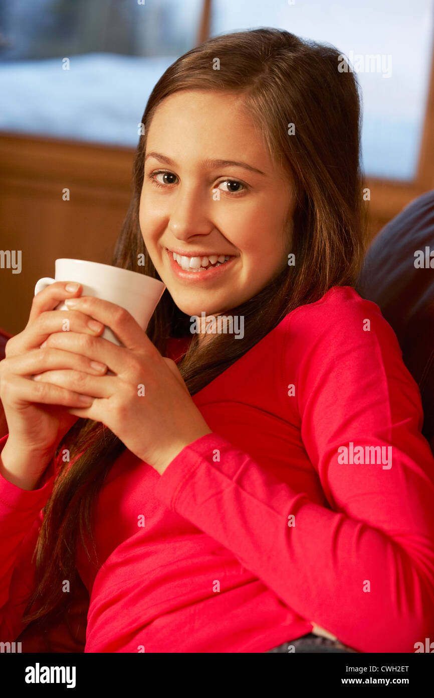 Teenage Girl Relaxing On Sofa With Hot Drink Stock Photo - Alamy