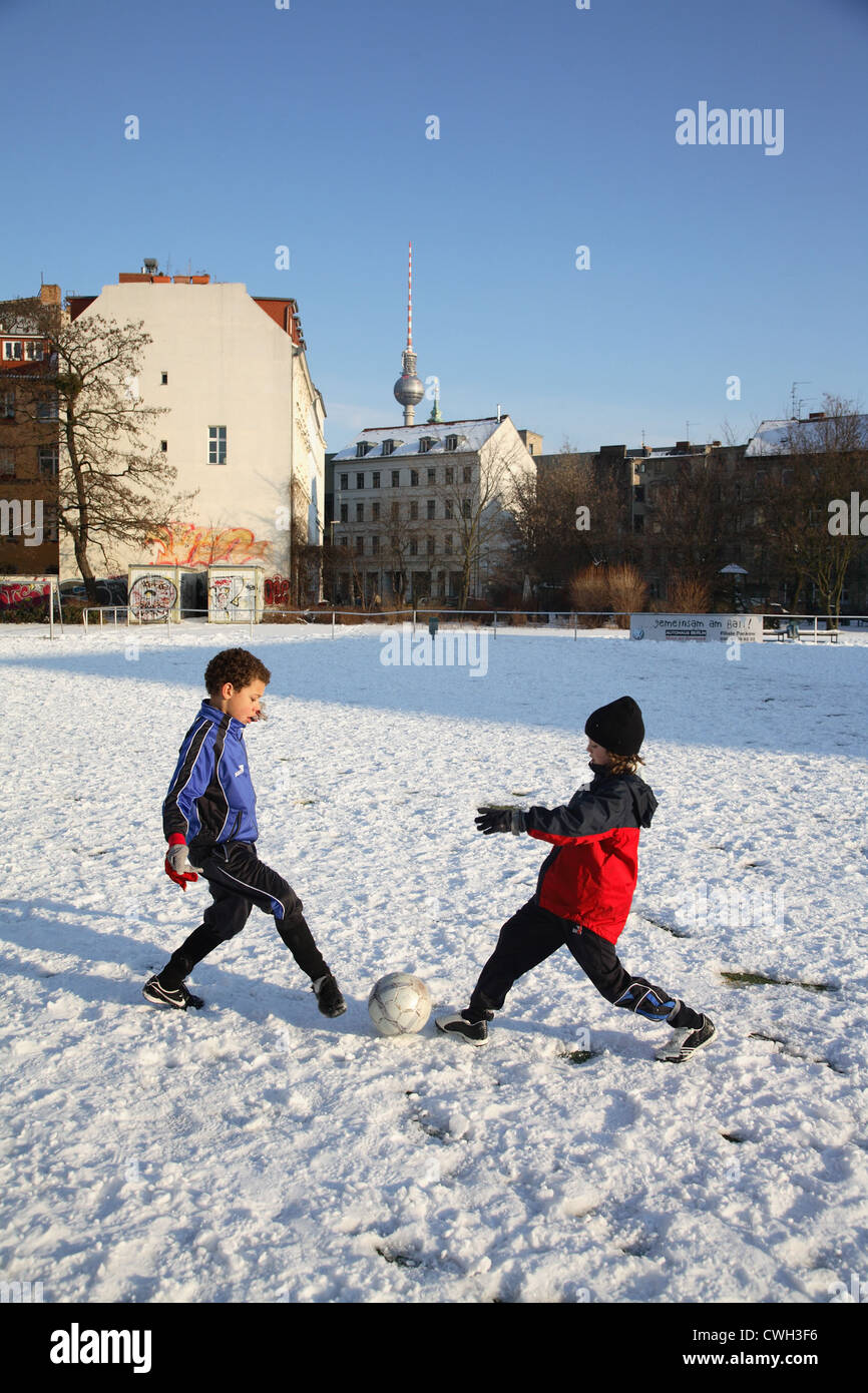 Boys playing football in the snow in Berlin Stock Photo