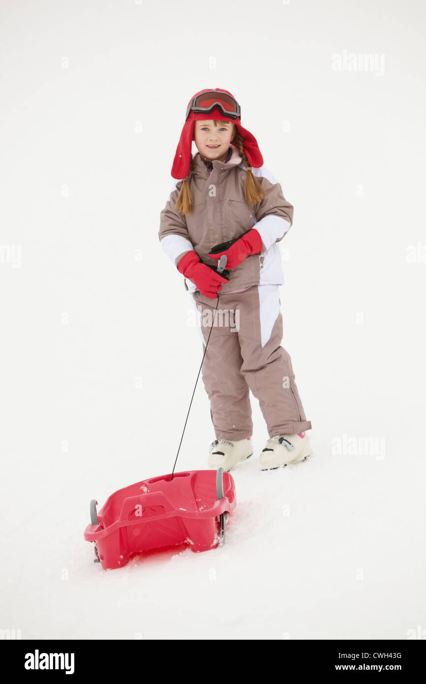 Young Girl Pulling Sledge On Ski Holiday In Mountains Stock Photo