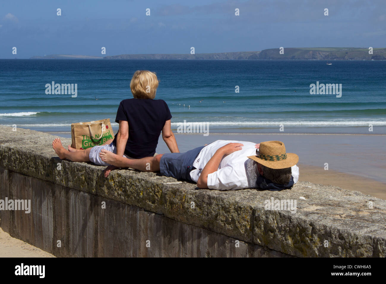 A couple sunbathe at Newquay Cornwall UK Stock Photo