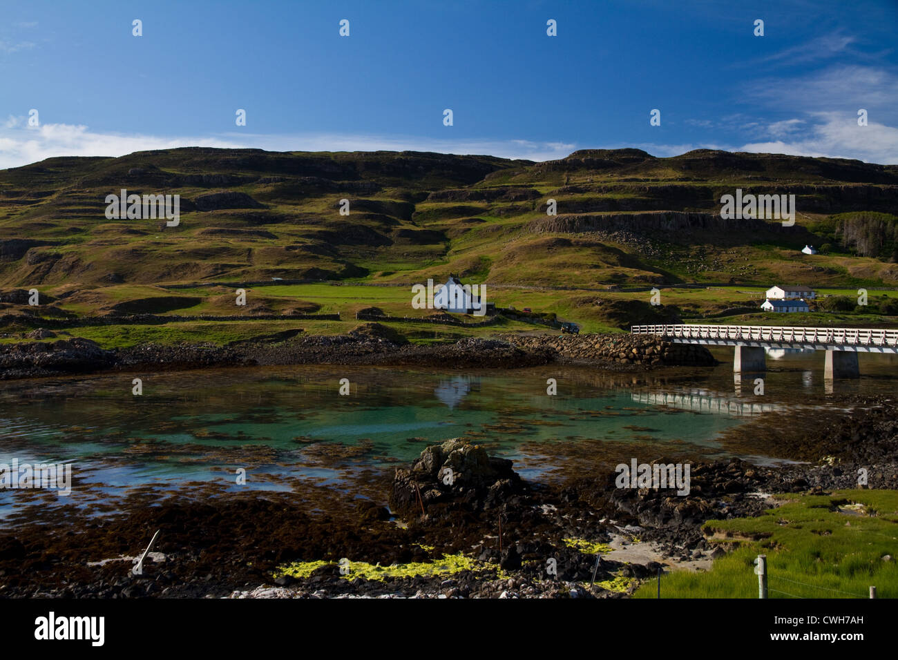 The bridge connecting Sanday and Canna, Small Isles, Scotland, with Canna's basalt terraces in the background Stock Photo
