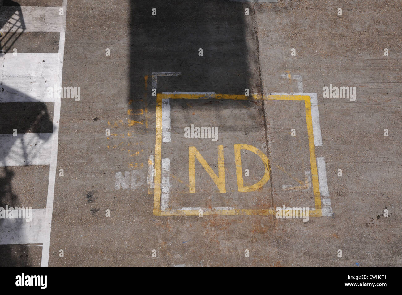 ND written in yellow on concrete dock, aerial view, Portsmouth harbour. Stock Photo