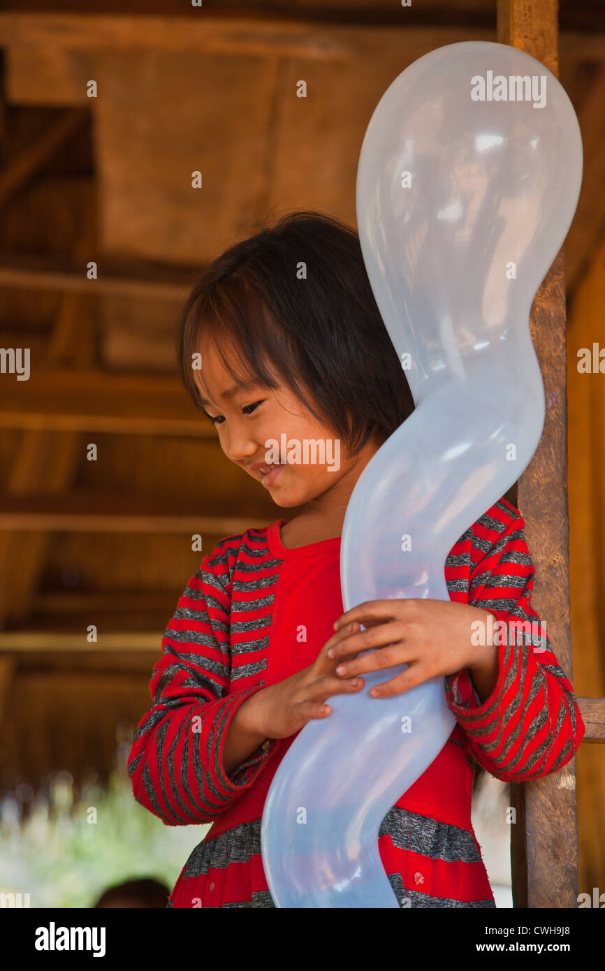 A young girl enjoys her BALLOON in a SHAN VILLAGE near KENGTUNG also known as KYAINGTONG - MYANMAR Stock Photo