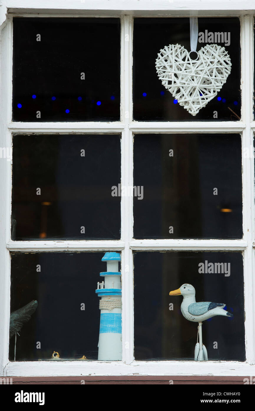 Heart shape, seagull and lighthouse ornament in a shop window.  Kington. Herefordshire, England Stock Photo