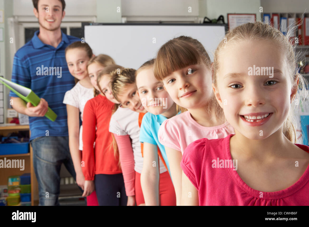 Teacher with line up of children in class Stock Photo