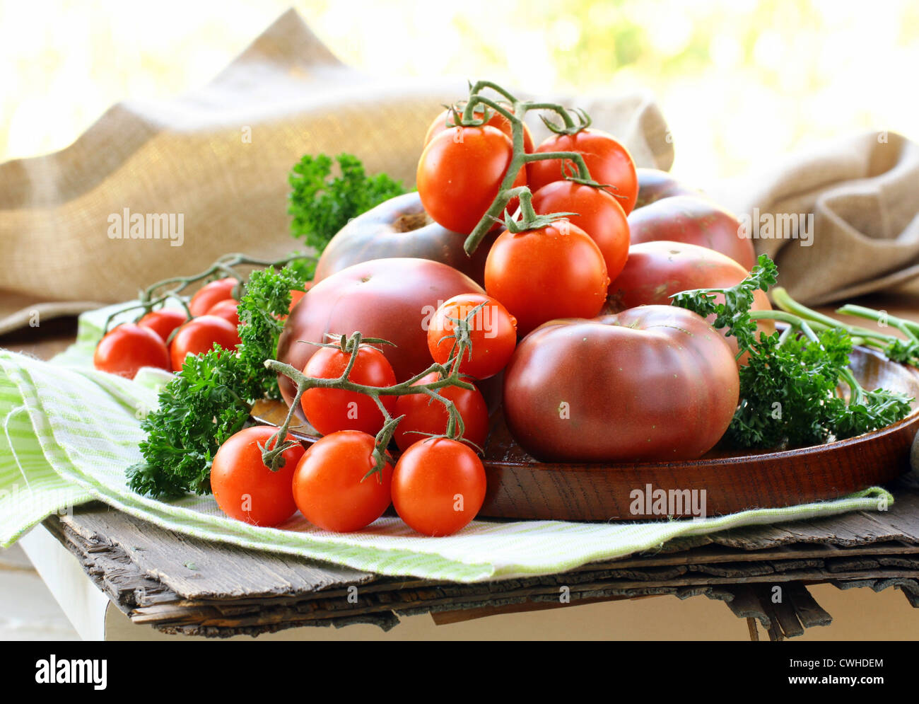 different varieties of tomatoes on wooden plate Stock Photo - Alamy
