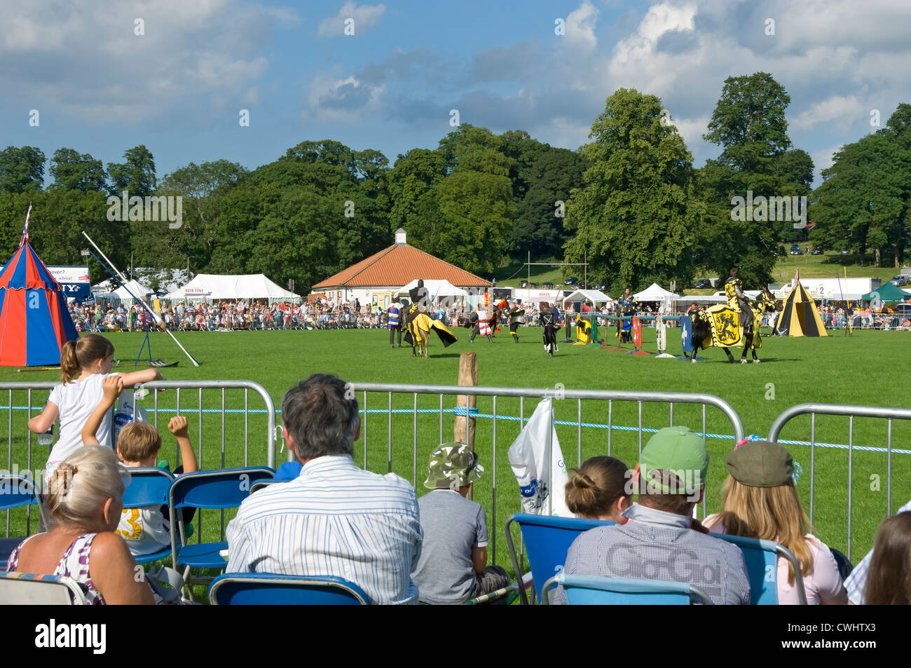 People visitors watching jousting display at Thornton le Dale Show showground in summer North