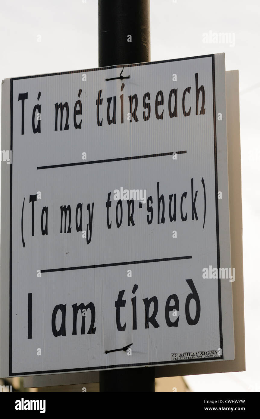 Sign on a lampost saying in Gaelic 'Ta me tuirseach', a phonetic spelling and English meaning 'I am tired' Stock Photo