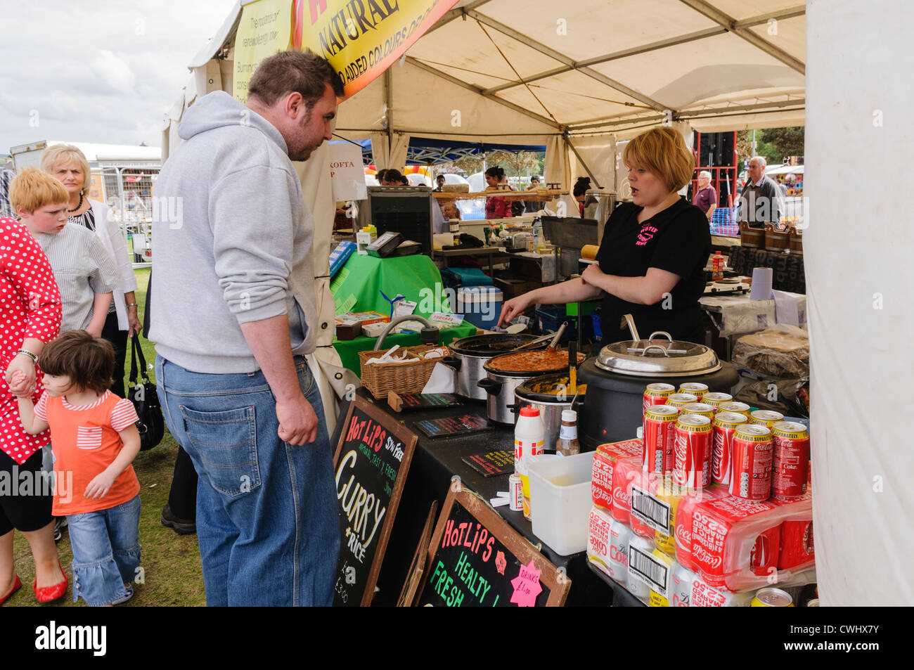 Man buys a curry from a market stall Stock Photo