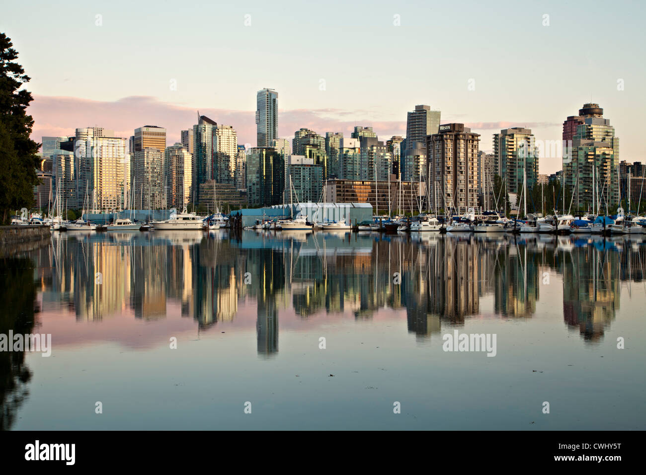 Vancouver British Columbia Canada skyline reflected in the water of Coal Harbor, there is a warm