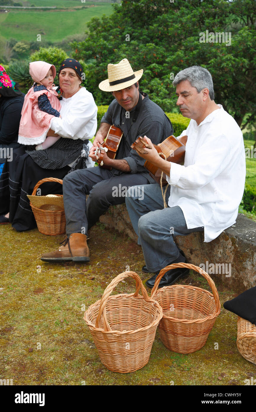 Men playing guitar outside, while wearing traditional garments. Sao ...