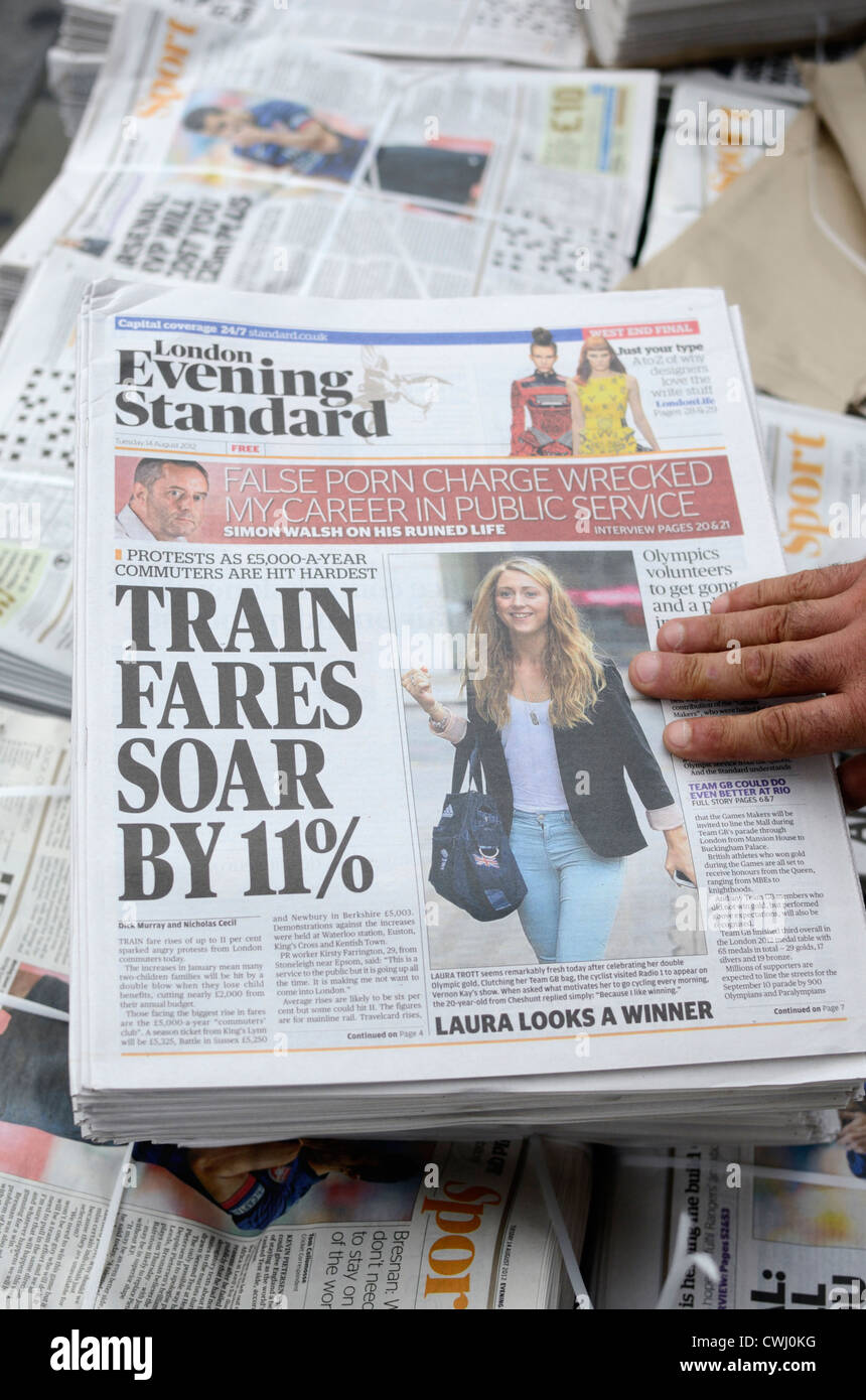 A hand grabbing a copy of the London Evening Standard newspaper Stock Photo