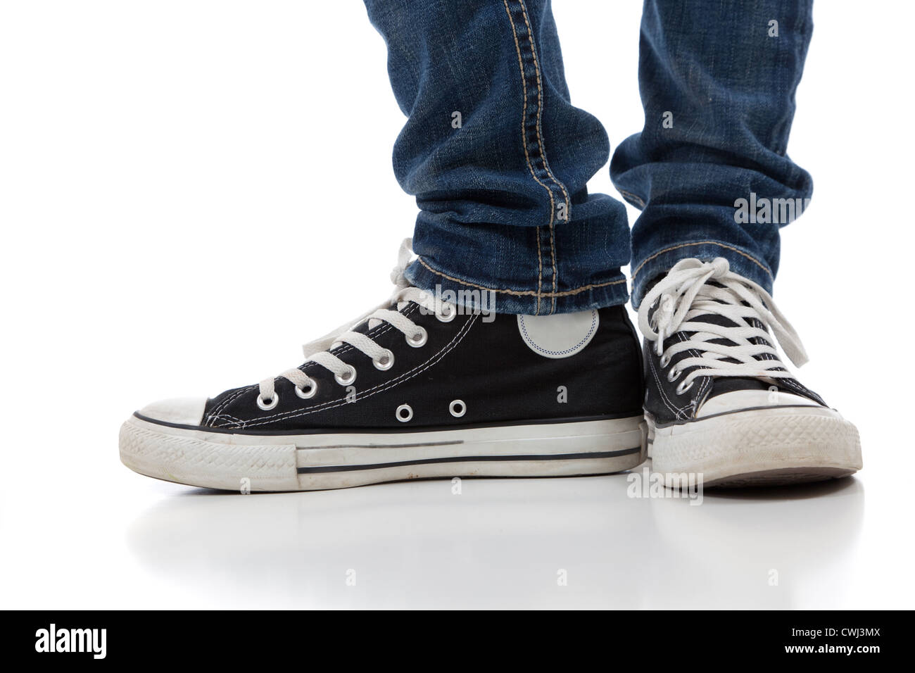 Person in blue denim jeans and black and white converse all star