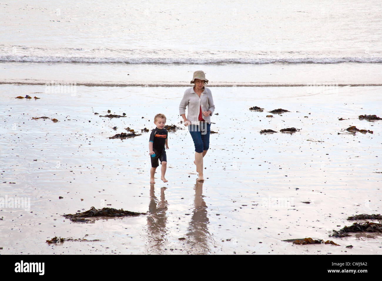 Three year old boy with his grandmother on Daymer bay beach near Rock, Cornwall, England, United Kingdom. Stock Photo