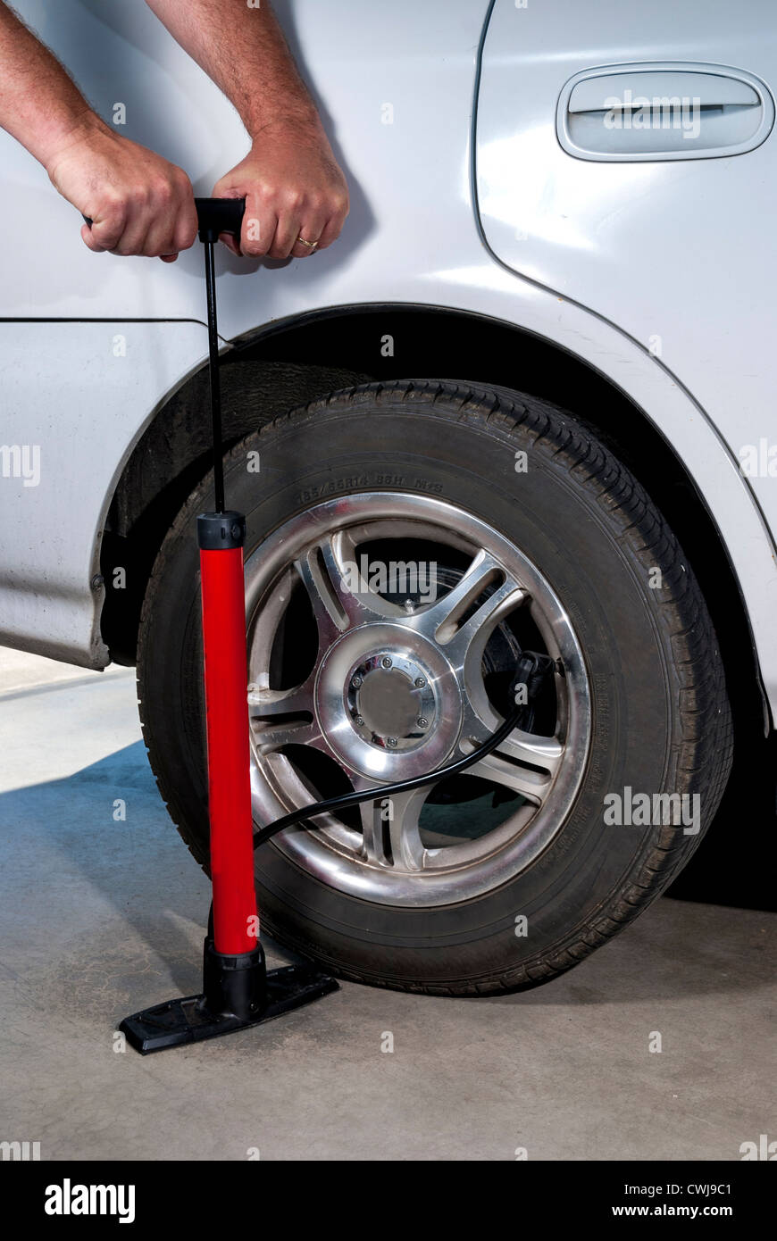 Using a hand pump to fill a car tire with air Stock Photo - Alamy