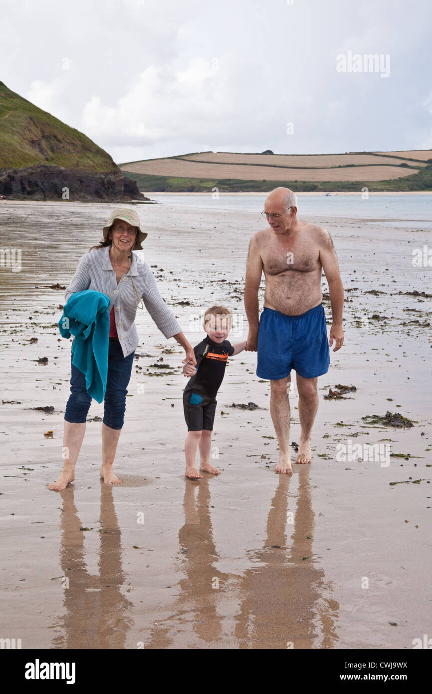 Three year old boy with his grandparents on Daymer bay beach near Rock, Cornwall, England, United Kingdom. Stock Photo