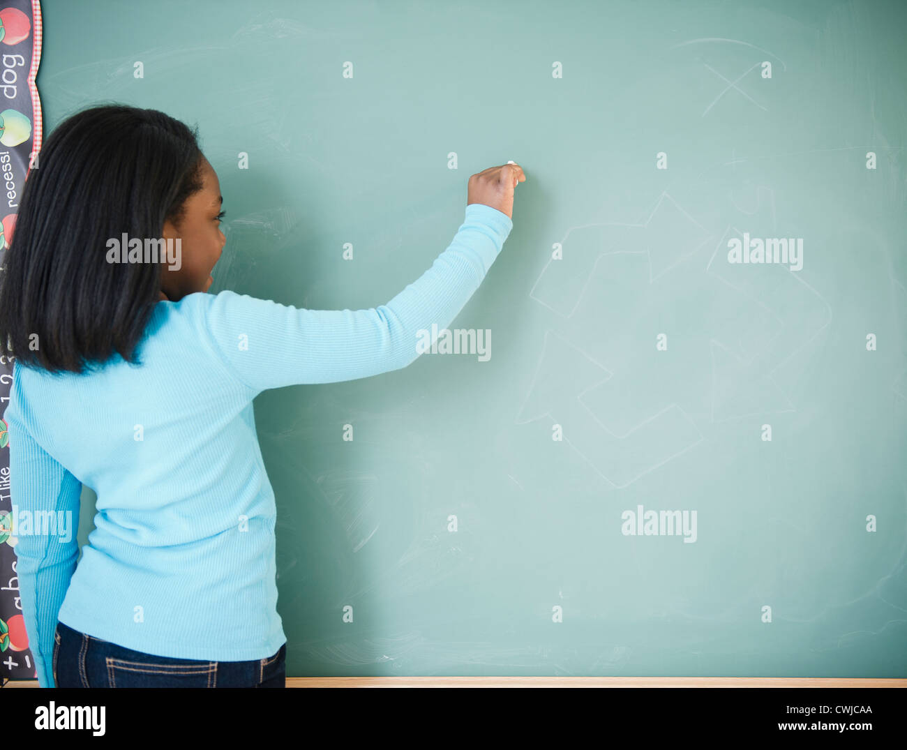 Black student writing on blackboard Stock Photo