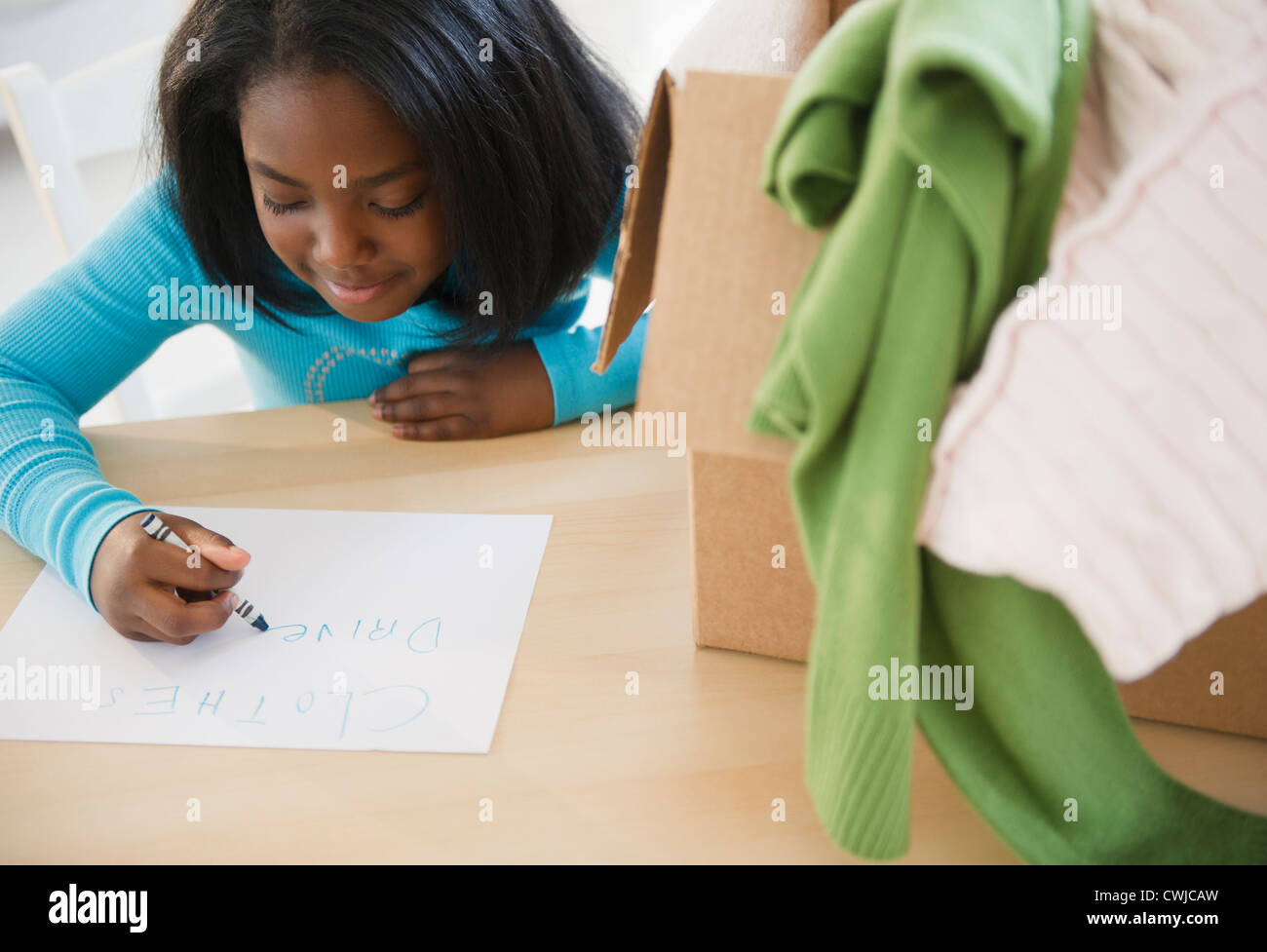 Black girl donating clothing to charity Stock Photo