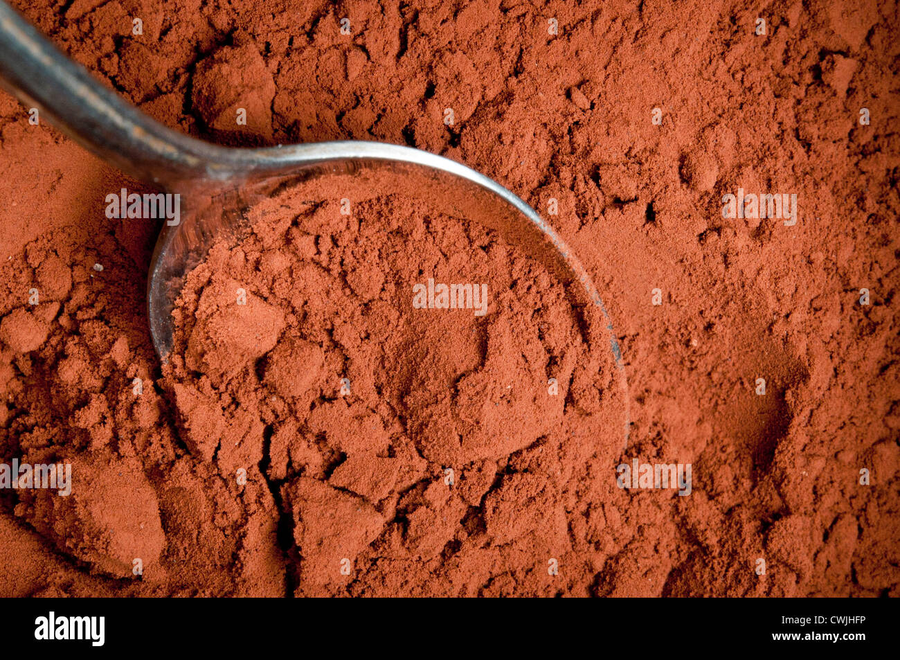 a spoon taking up some cocoa powder Stock Photo