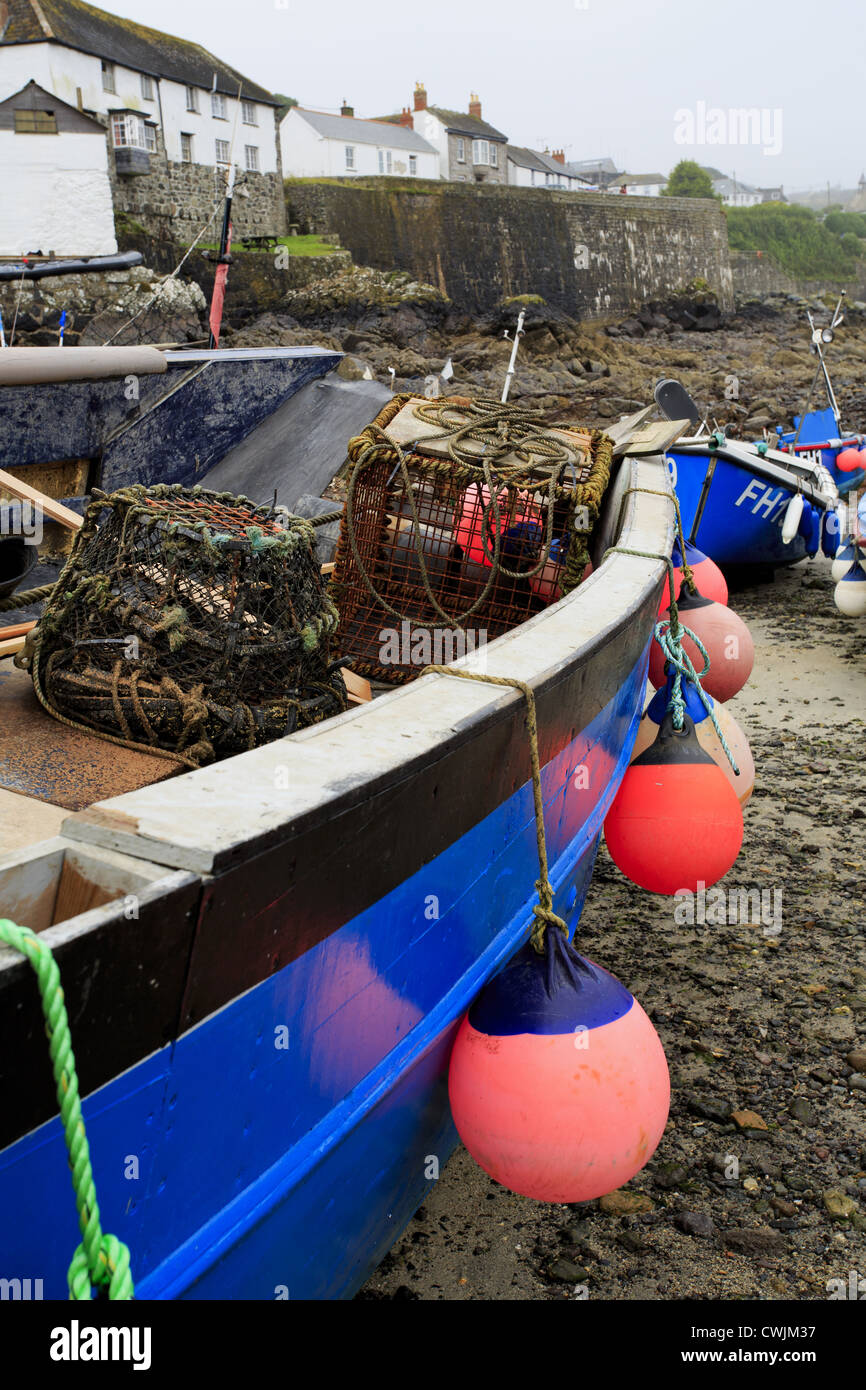 Traditional Cornish lobster fishing boat with village in background Stock Photo