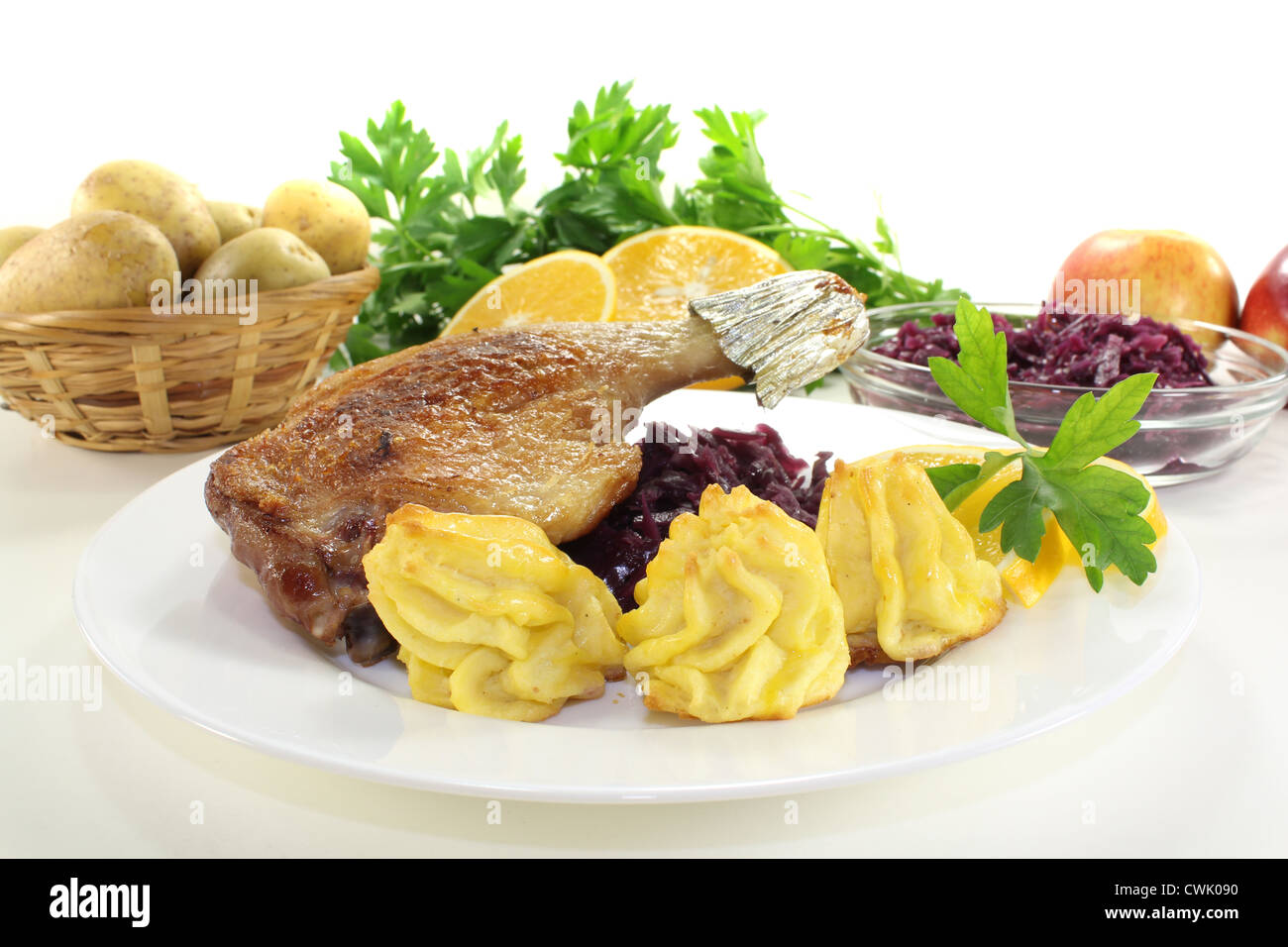 fried Duck drumstick with duchess potatoes and red cabbage on a light