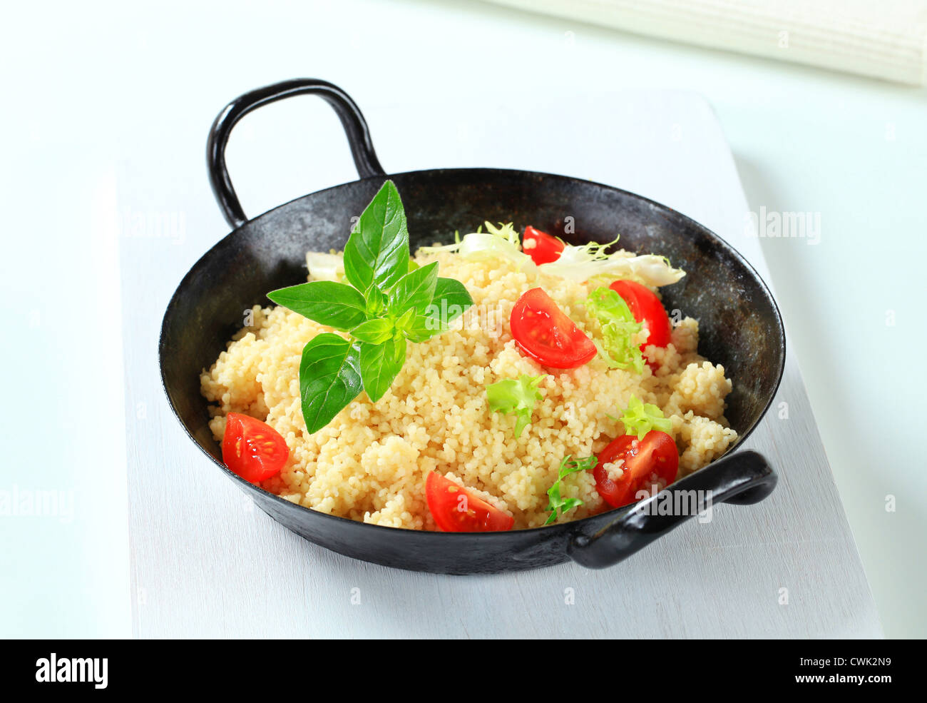 Couscous with salad greens and tomato in a pan Stock Photo