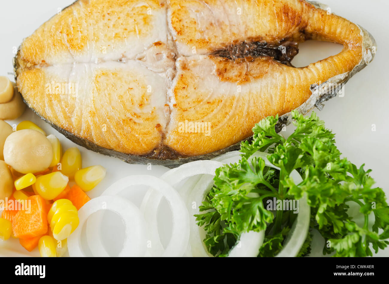 A piece of fried fish with coriander leaves, corn, carrot, mushroom