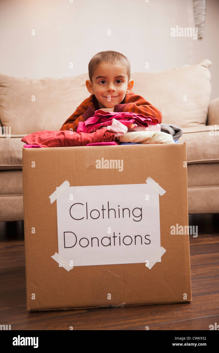 Caucasian boy donating clothing Stock Photo