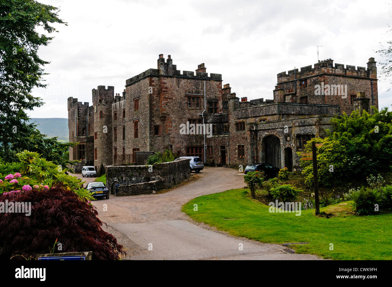 A gravel driveway for vehicles leads to Muncaster Castle set in 70 acres of gardens famous for its collection of rhododendrons Stock Photo