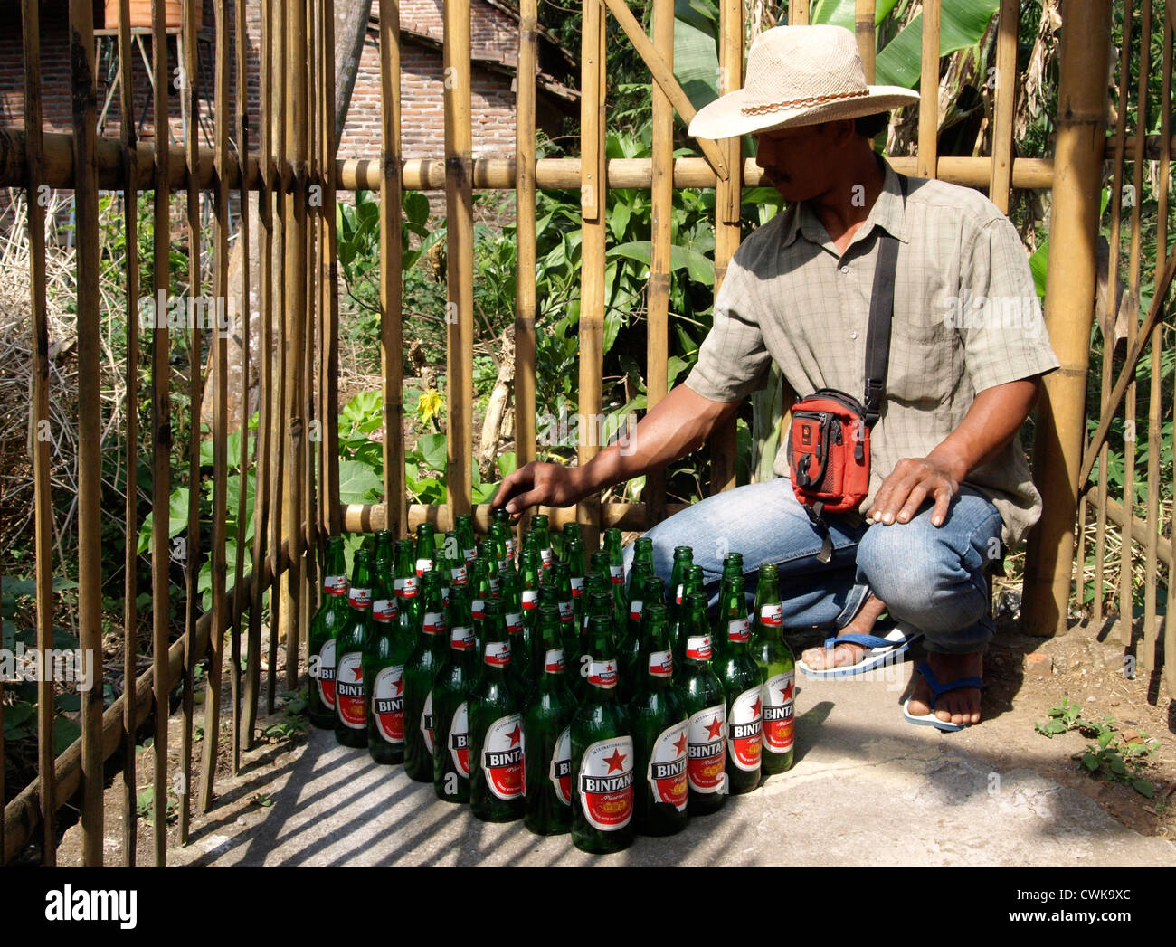 local man with large collection of empty beer bottles for recycling Stock Photo