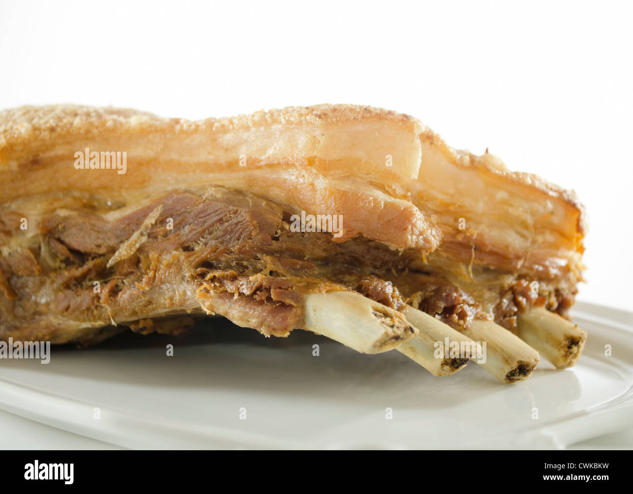 Big piece of deepfried pork belly on white serving plate Stock Photo