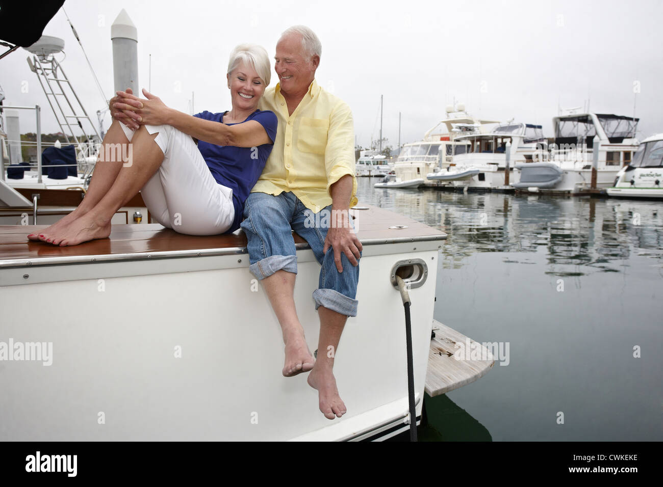 Couple relaxing on boat in marina Stock Photo