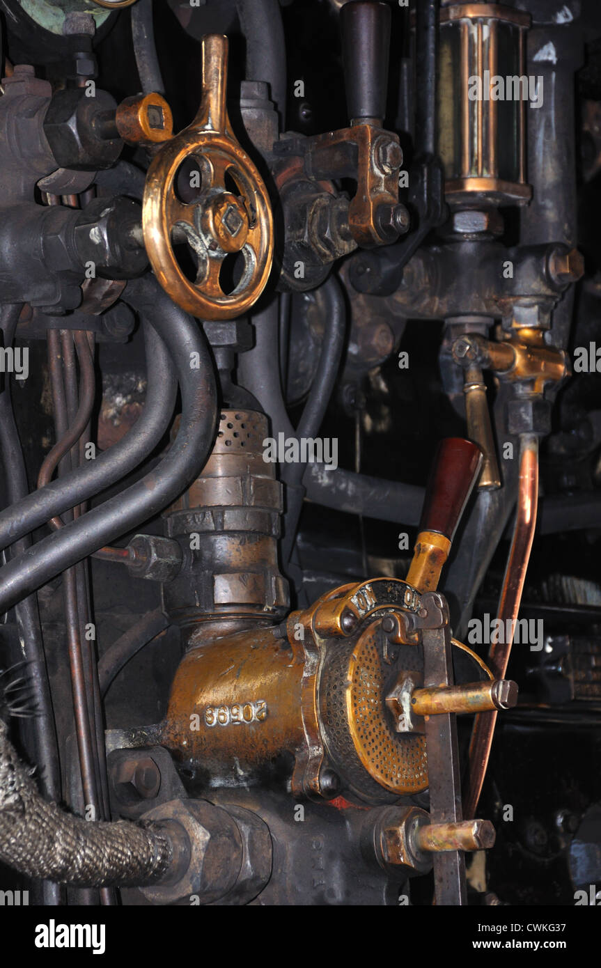 Brass wheels, valves and pipes that make up the engine of a steam train
