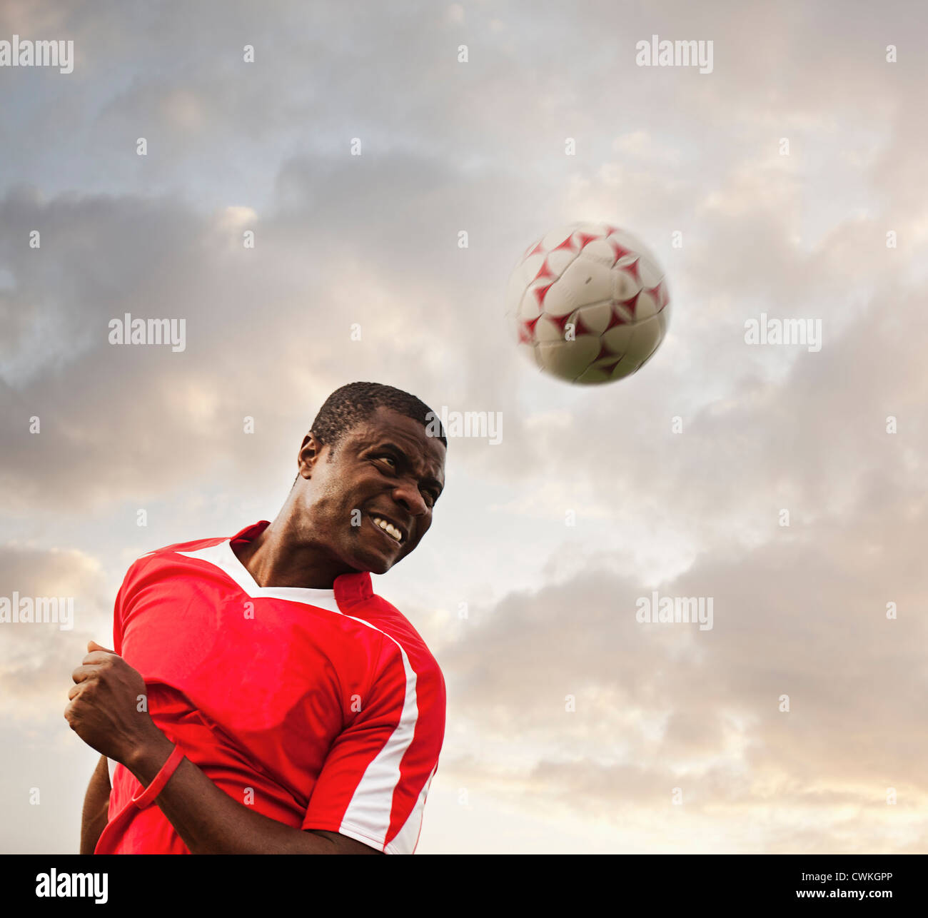 Black soccer player heading the ball Stock Photo