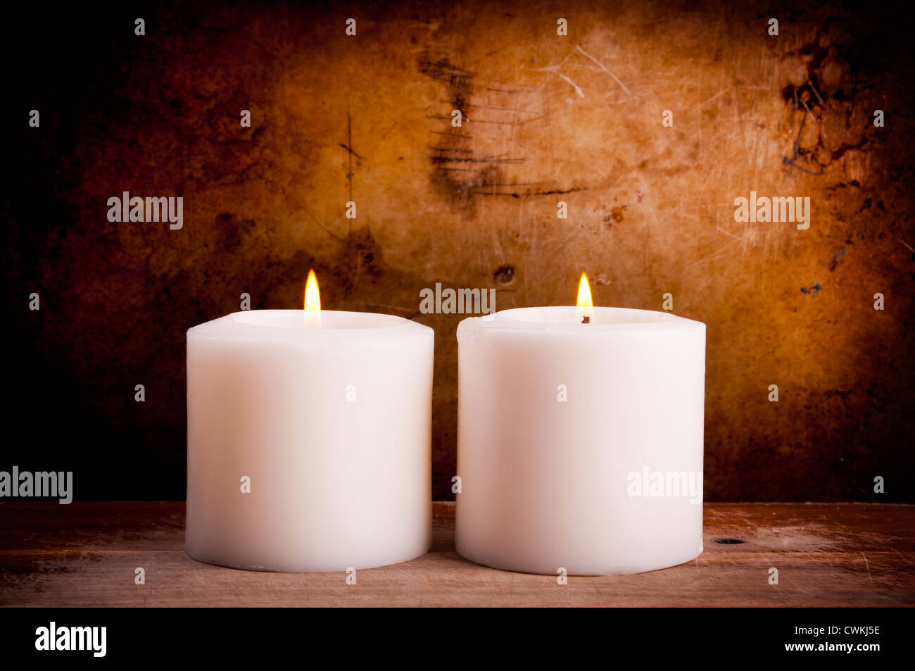 White candles burning with a textured vintage background Stock Photo