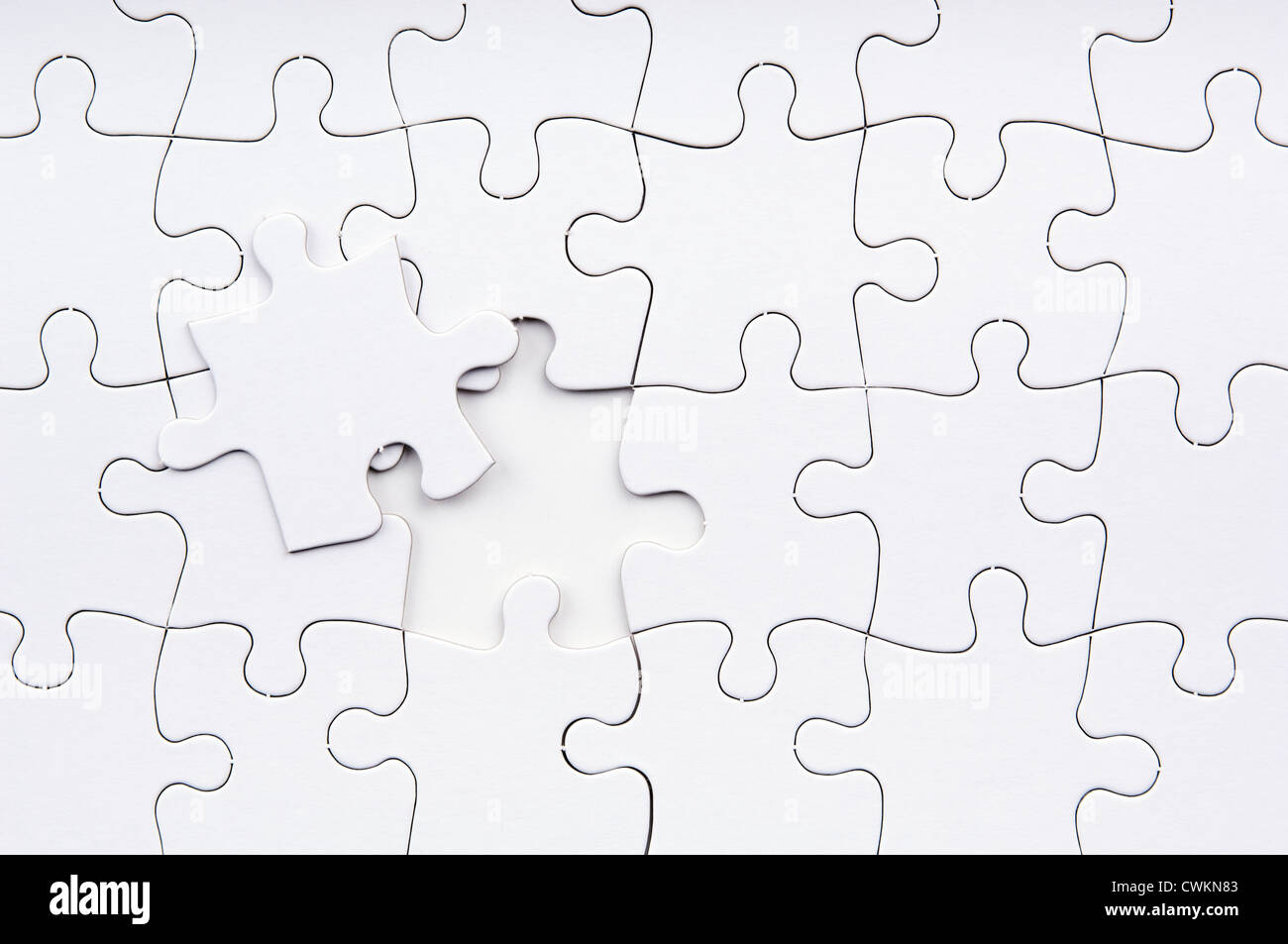 Jigsaw puzzle in white with a missing piece Stock Photo