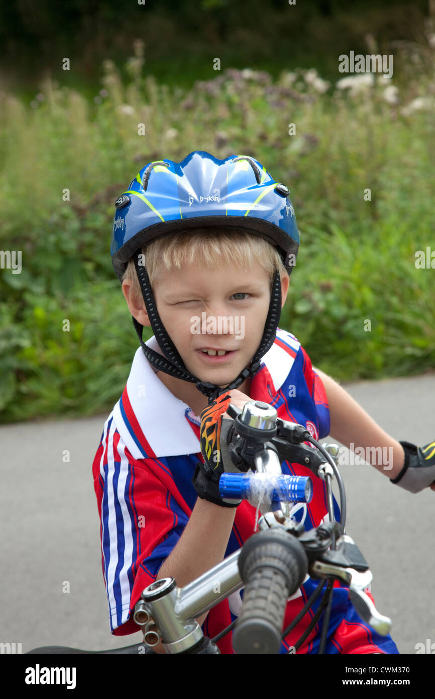 Winking Polish bicycler boy age 8 wearing a helmet. Zawady Central Poland Stock Photo