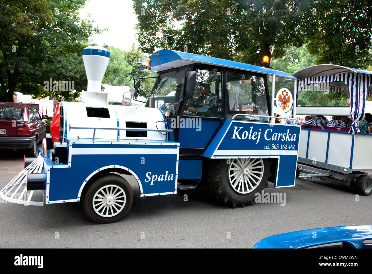 Railroad like engine pulling trailer of sightseers around country fair (Rynek). Spala Central Poland Stock Photo