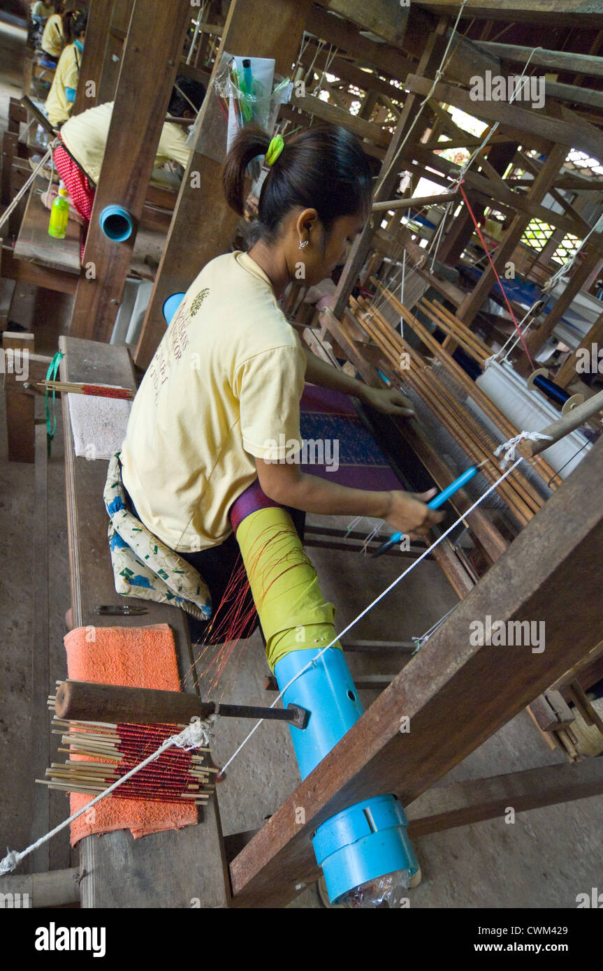 Vertical close up of women weaving the silk threads into fabric on a