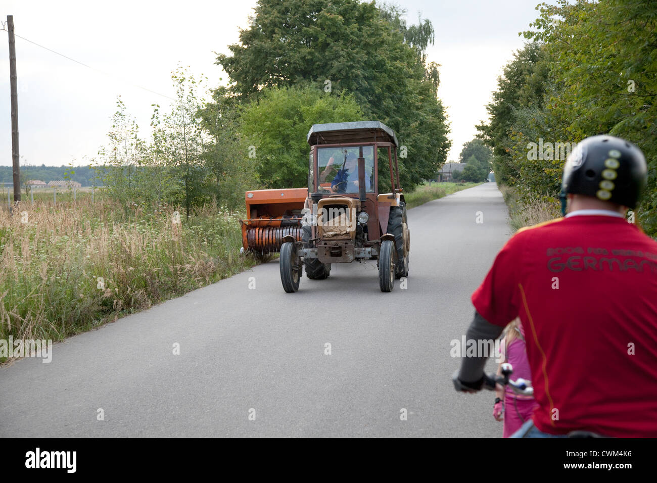 Polish tractor clipping back weeds along the shoulder of the road. Zawady Central Poland Stock Photo
