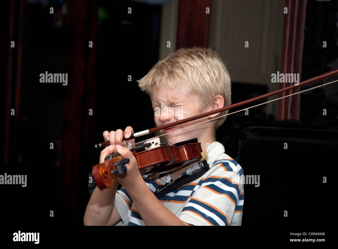 Boy age 8 wincing at a bad squeaky note from his violin. Zawady Central  Poland Stock Photo - Alamy