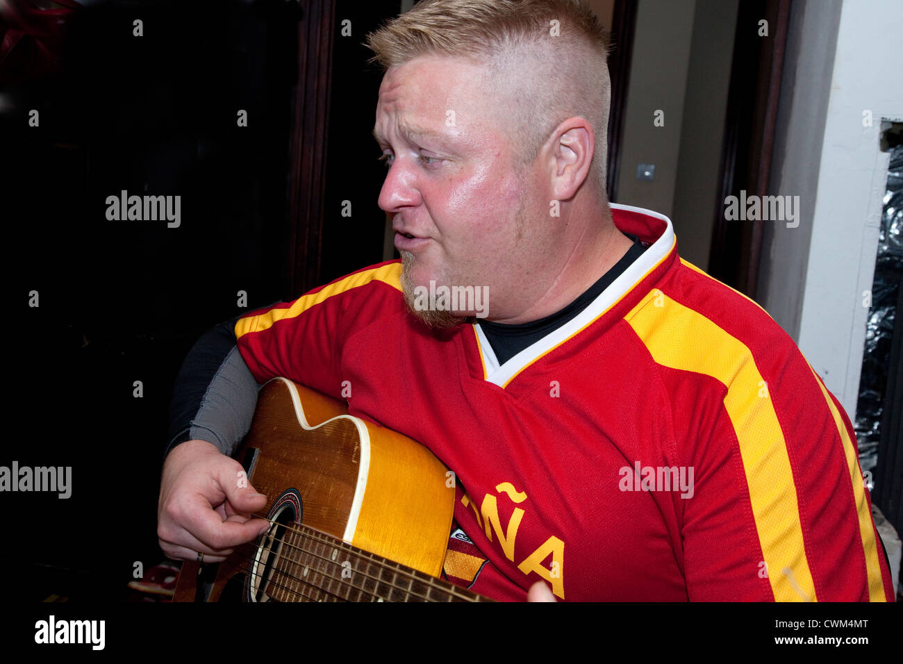 Man age 37 strumming his guitar and singing at home. Zawady Central Poland Stock Photo